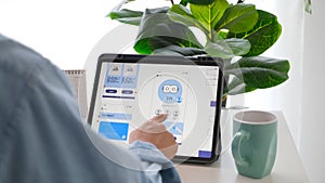 Man hand holding digital tablet with mobile app development prototype while working at home