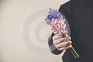 Man hand holding flowers. Bouquet of flowers for congratulations