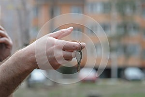 Man hand holding house key concept realtor work