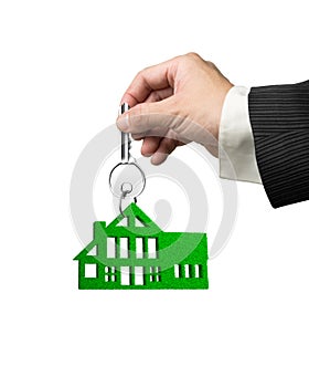Man hand holding key with green grass house shape keyring