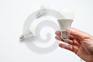 Man hand holding led light bulb on white background. Closeup. Energy saving. Point of view shoot. Energy efficient lighting choice