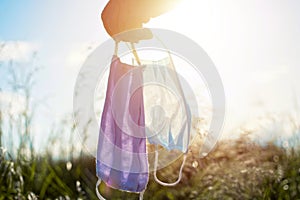 Man hand holding mask, protective masks against sun light. Concept of freedom during covid 19. Positivity through quarantine