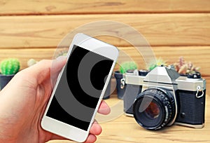 Man hand holding mobile phone blank screen with camera cactus an