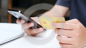 Man hand holding mobile phone and credit card for shopping online