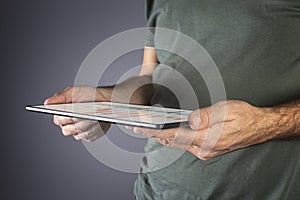 Man hand holding a modern tablet with financial graph.