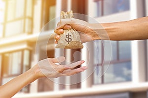 A man hand holding a money giving to another person for buying r