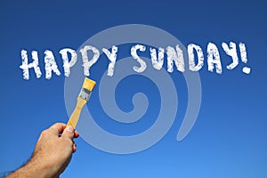 man hand holding paint brush with the text happy sunday