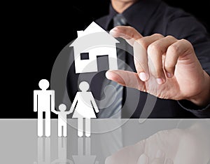 Man hand holding paper house with family