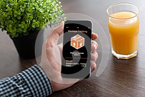 Man hand holding phone with app tracking delivery package screen