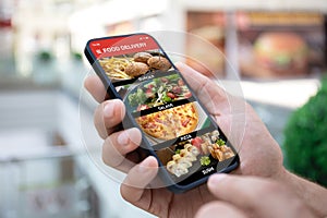 Man hand holding phone with food delivery app on screen