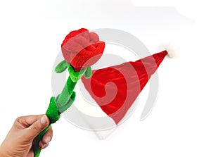 Man hand holding the phony red rose with green stalk above santa