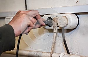 Man hand holding and pull electronic plug