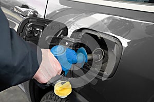 A man hand holding pump filling gasoline. Pumping petrol into the tank. A car refuel on gas station