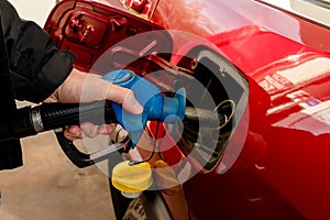 A man hand holding pump filling gasoline. Pumping petrol into the tank. A car refuel on gas station