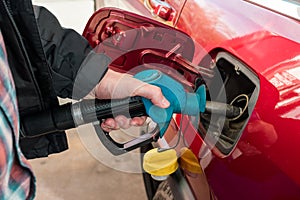 A man hand holding pump filling gasoline. Pumping petrol into the tank. A car refuel on gas station