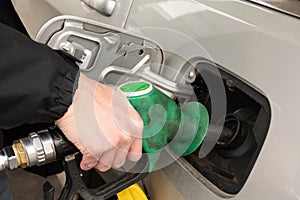 A man hand holding pump filling gasoline. Pumping petrol into the tank. A car refuel on gas station