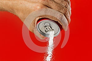 Man hand holding refresh drink can pouring sugar stream in sweet and calories content of soda and energy drinks