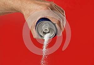 Man hand holding refresh drink can pouring sugar stream in sweet and calories content of soda and energy drinks