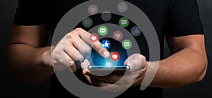 man hand holding smartphone with virtual social media icon. Social media and digital online concept. close up, dark background