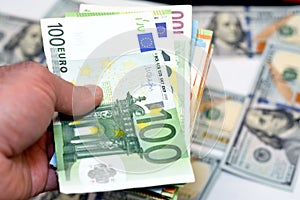 man hand holding a stack of 100 one hundred European euros banknotes money, spending, giving and using money concept, paying