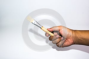 Man hand holding the wooden paint brush