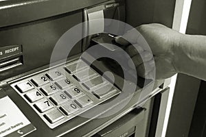 Man hand insert card to automated teller machine ATM black and white