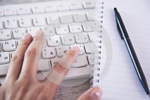 Man hand keyboard with notepad