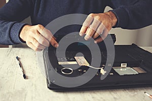 Man hand laptop disassembling