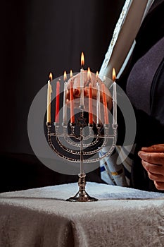 Man hand lighting candles in menorah hanukka lights candles