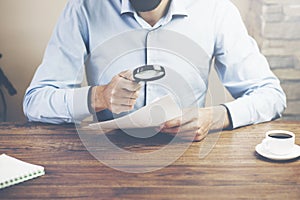 Man hand magnifier and doument