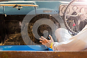 Man hand on manual gear of old car.