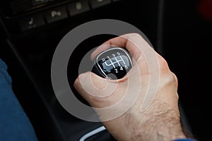 Man hand on a mechanical gearbox in the car. Man driving car. Car interior details. Car 6 speed transmission