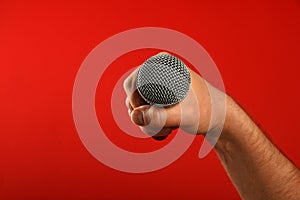 Man hand with microphone over red background