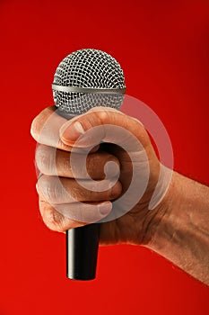 Man hand with microphone over red background