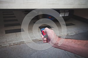 Man hand open the garage door with remote control