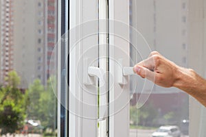 Man Hand opens a plastic pvc window.