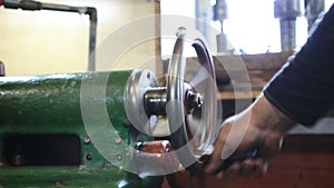 Man hand operating old controls of turning machine