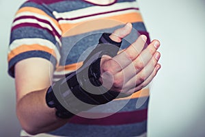 Man with hand in orthopedic black orthosis