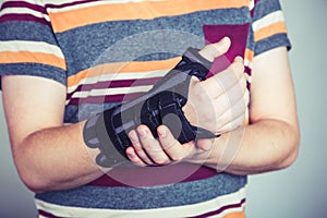 Man with hand in orthopedic black orthosis