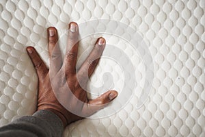 man hand on Orthopedic pillow on a bed