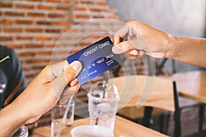 Man hand paying his drinks by credit card in coffee shop