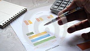 man hand with pen analyzing bar chart on paper