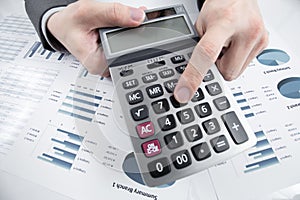 Man hand with pen and business report on table