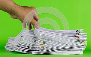 man hand picking up paper in stack documents on green