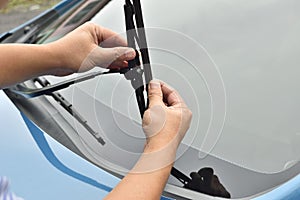 Man hand picking up windscreen wiper photo