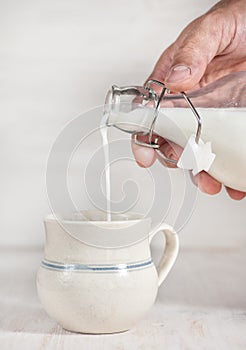 Man hand pouring milk from bottle