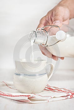 Man hand pouring milk from bottle