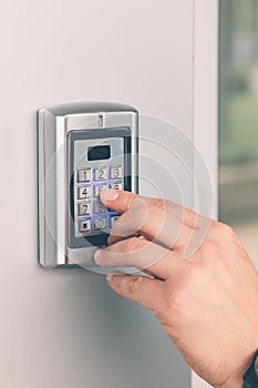 Man hand pressing the security code combination to unlock the door