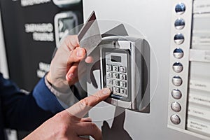 Man hand pressing the security code combination and using key card to unlock the door