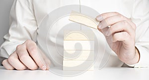 Man hand put wooden blocks in the shape of a staircase isolated on white background with copy space. Concept of building success